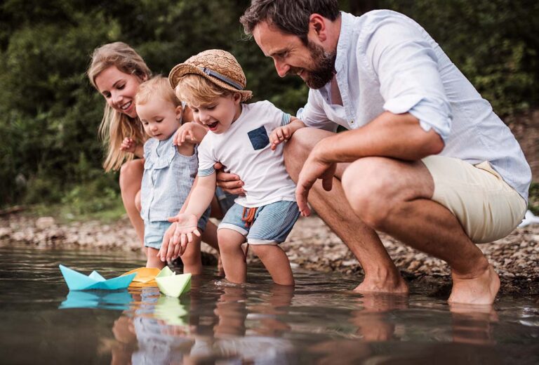 Family playing by a river, representing the quality of life benefits of early MS diagnosis and treatment