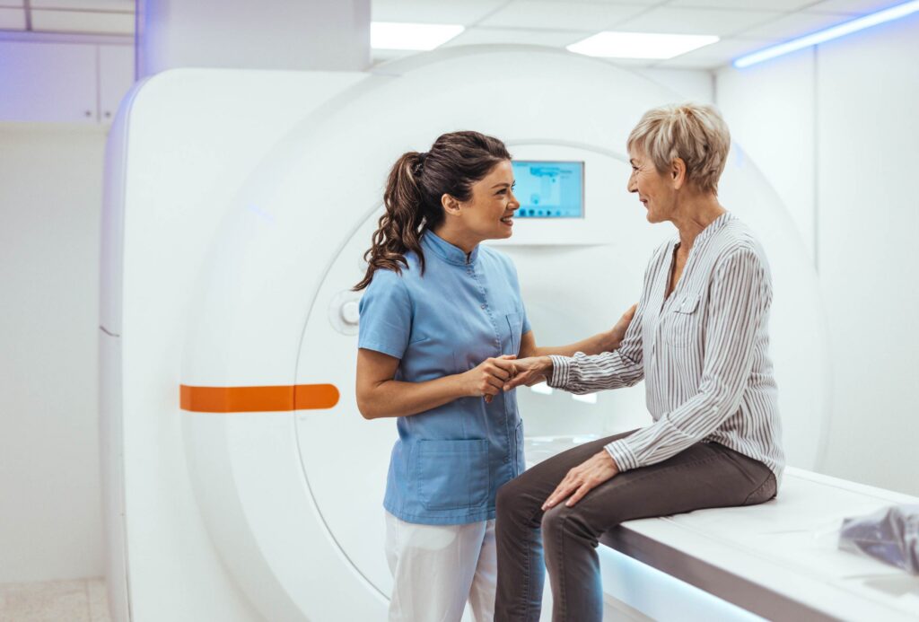 A CT tech leads a patient through a CT angriogram.